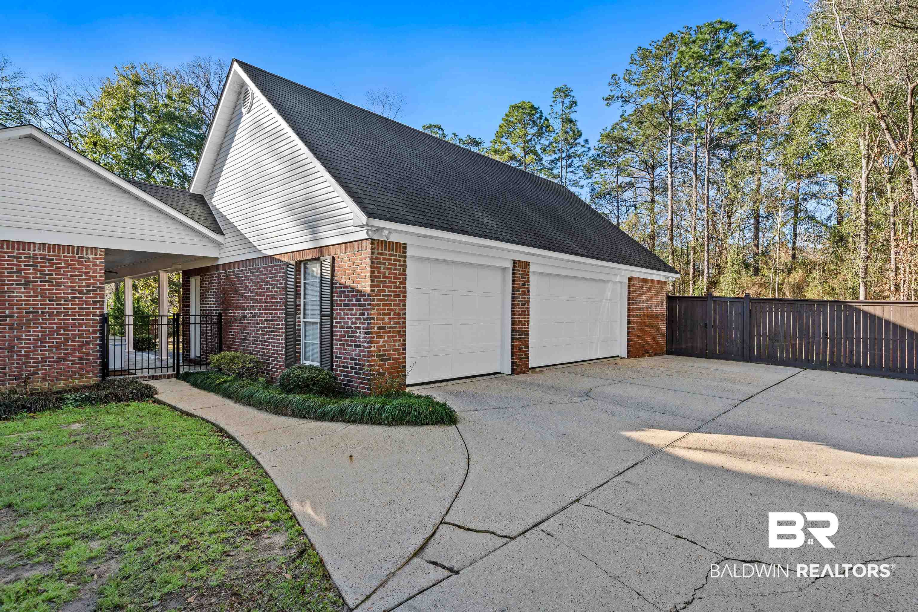 31267 Blakeley Ridge Court Spanish Fort, AL 36527 - Photo 49 of 61 View of property exterior with brick siding, a shingled roof, concrete driveway, an attached garage, and fence