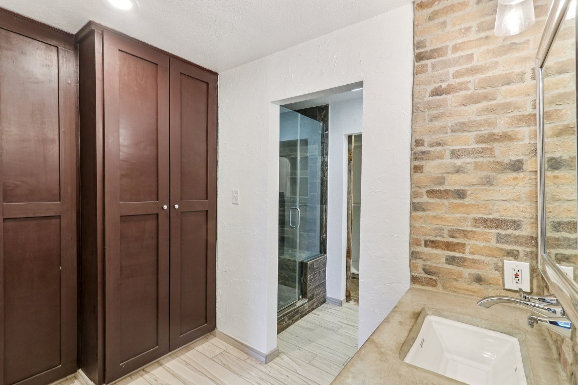 24369-2 Bingham Creek Road, Unit 12 Leander, TX 78641 - Photo 14 of 22 a bathroom with a granite countertop shower and a sink