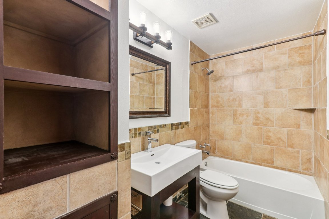 24369-2 Bingham Creek Road, Unit 12 Leander, TX 78641 - Photo 15 of 22 a bathroom with a sink a toilet tub and shower