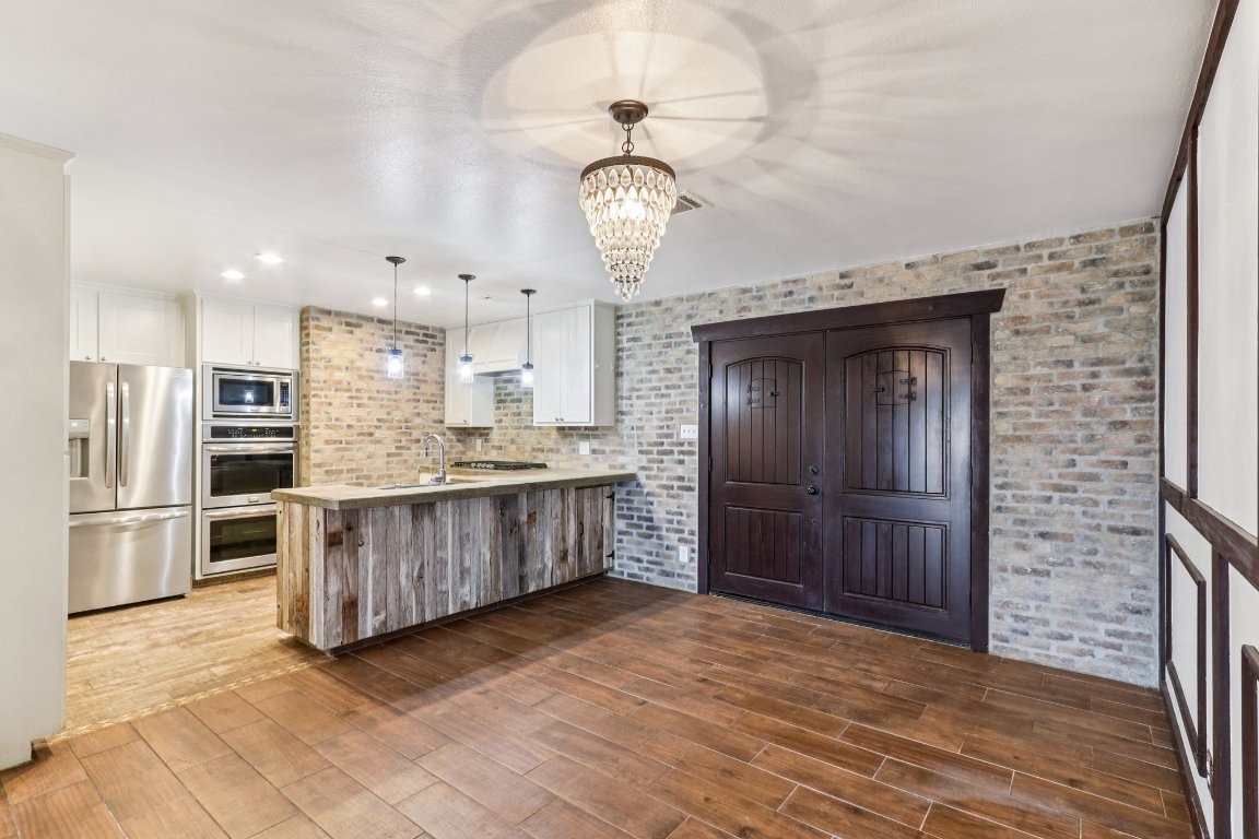 24369-2 Bingham Creek Road, Unit 12 Leander, TX 78641 - Photo 7 of 22 a large kitchen with a large counter top stainless steel appliances and cabinets