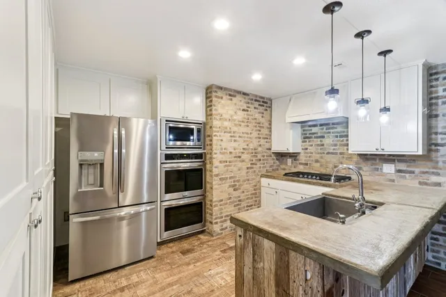 a kitchen that has a refrigerator a sink a stove and a center island