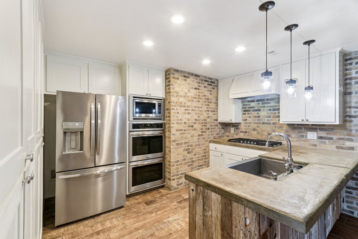 24369-2 Bingham Creek Road, Unit 12 Leander, TX 78641 - Photo 10 of 22 a kitchen that has a refrigerator a sink a stove and a center island