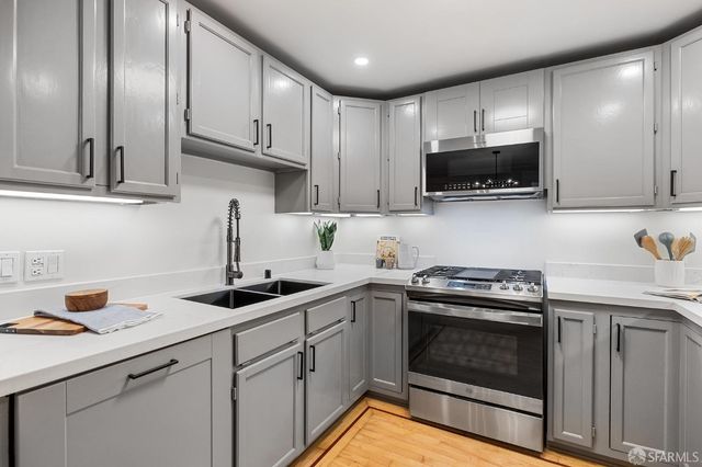 a kitchen with stainless steel appliances granite countertop a sink stove and cabinets