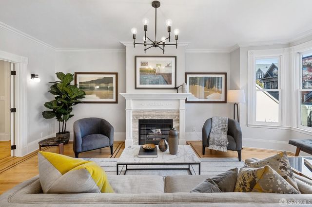a living room with furniture a chandelier and a fireplace