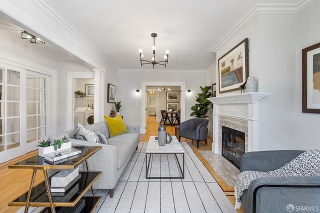 a living room with furniture and a chandelier