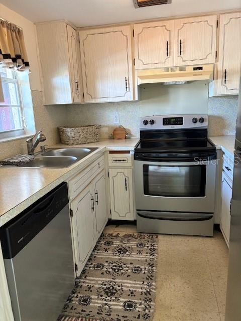4609 Marine Parkway, Unit 203 New Port Richey, FL 34652 - Photo 14 of 25 a kitchen with stainless steel appliances granite countertop a sink stove and cabinets