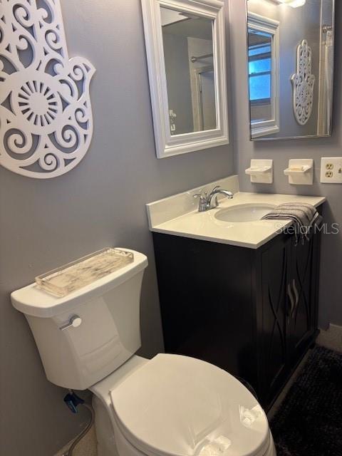 4609 Marine Parkway, Unit 203 New Port Richey, FL 34652 - Photo 17 of 25 a bathroom with a toilet a sink and a mirror