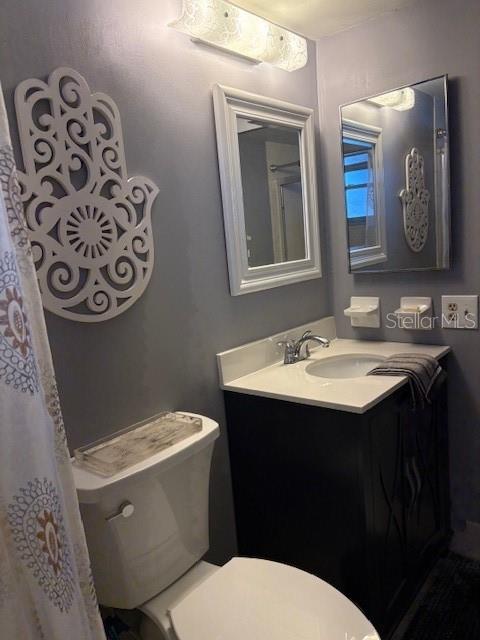 4609 Marine Parkway, Unit 203 New Port Richey, FL 34652 - Photo 18 of 25 a bathroom with a toilet sink and mirror