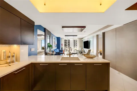 a kitchen with sink a large mirror and cabinets