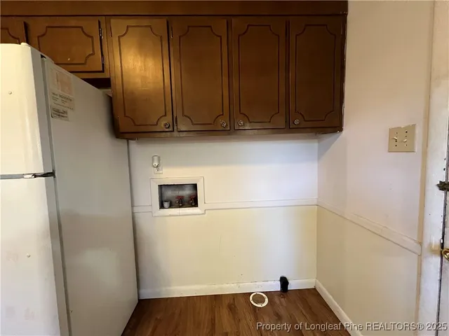a view of a storage and utility room with wooden floor