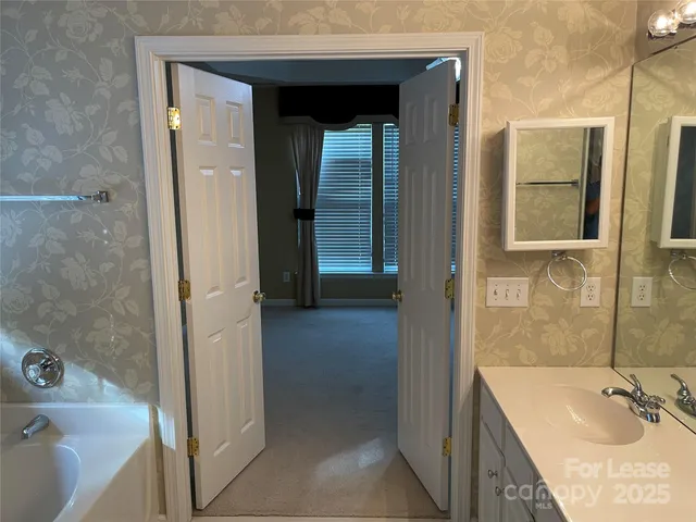 a bathroom with a tub sink and mirror