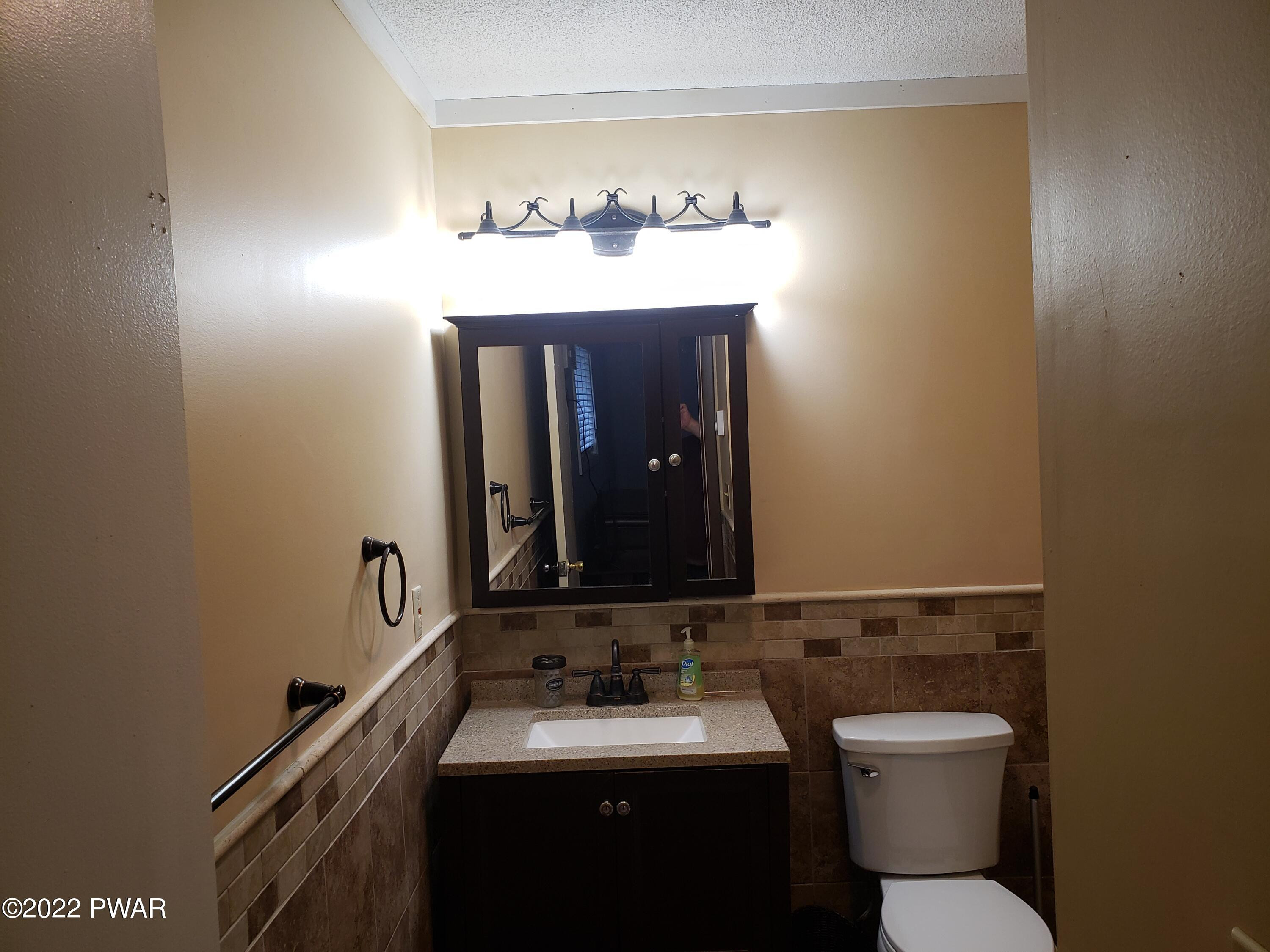 40 Crest View Road Lake Ariel, PA 18436 - Photo 13 of 32 a bathroom with a toilet sink and mirror