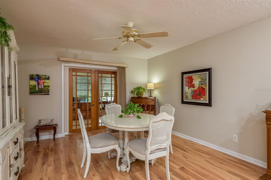 3184 Brunswick Circle Palm Harbor, FL 34684 - Photo 14 of 57 a dining room with furniture potted plants and wooden floor