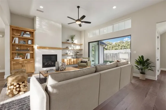 a living room with furniture fireplace and a large window