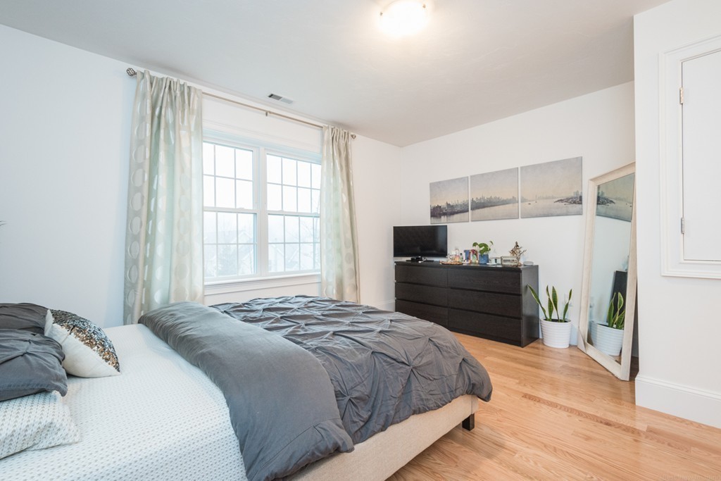 143 Broad Street, Unit 20 Hudson, MA 01749 - Photo 18 of 30 a bedroom with a bed and wooden floor