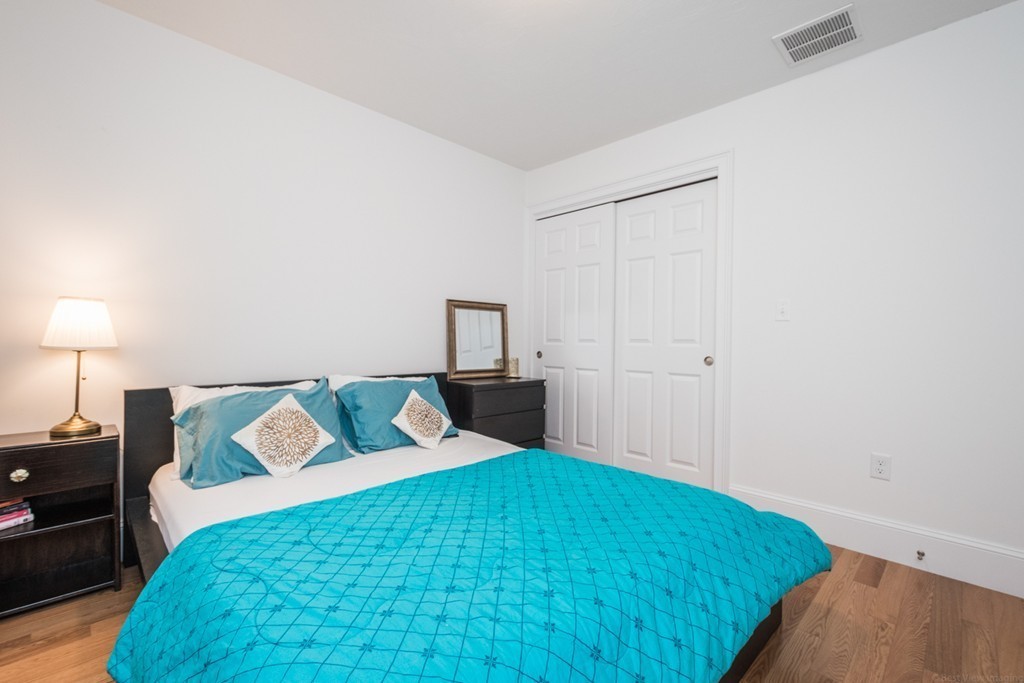 143 Broad Street, Unit 20 Hudson, MA 01749 - Photo 21 of 30 a bedroom with a bed and a lamp