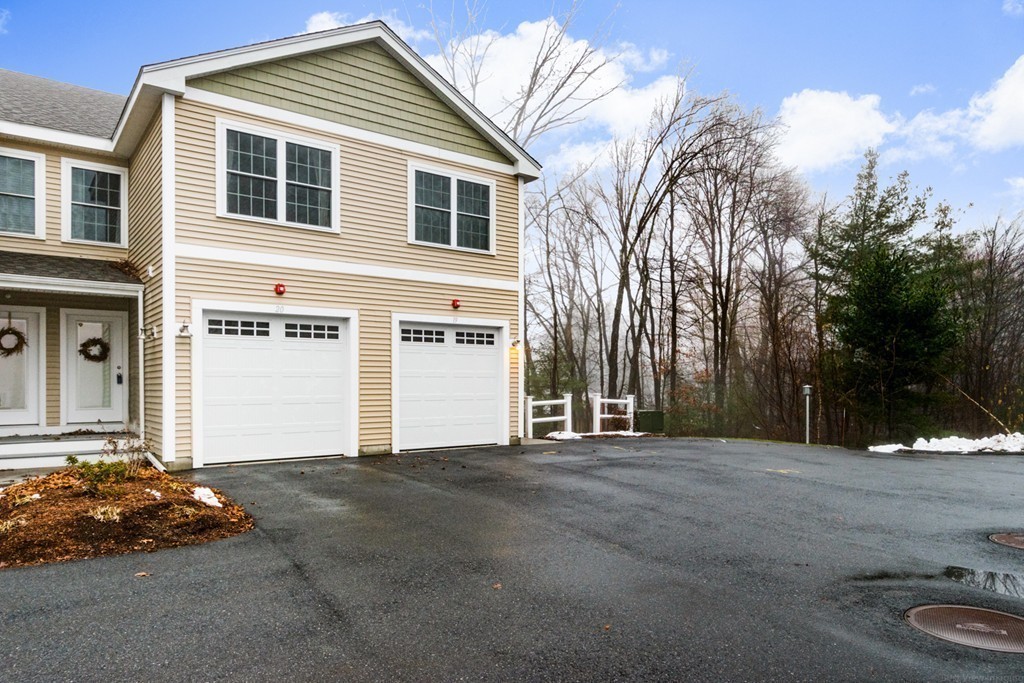 143 Broad Street, Unit 20 Hudson, MA 01749 - Photo 26 of 30 a front view of a house with a yard and garage