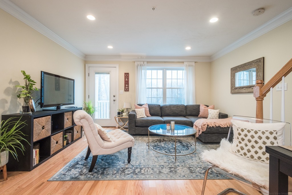 143 Broad Street, Unit 20 Hudson, MA 01749 - Photo 4 of 30 a living room with furniture and a flat screen tv
