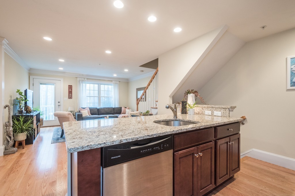143 Broad Street, Unit 20 Hudson, MA 01749 - Photo 9 of 30 a kitchen with granite countertop kitchen island a sink stove and dining table