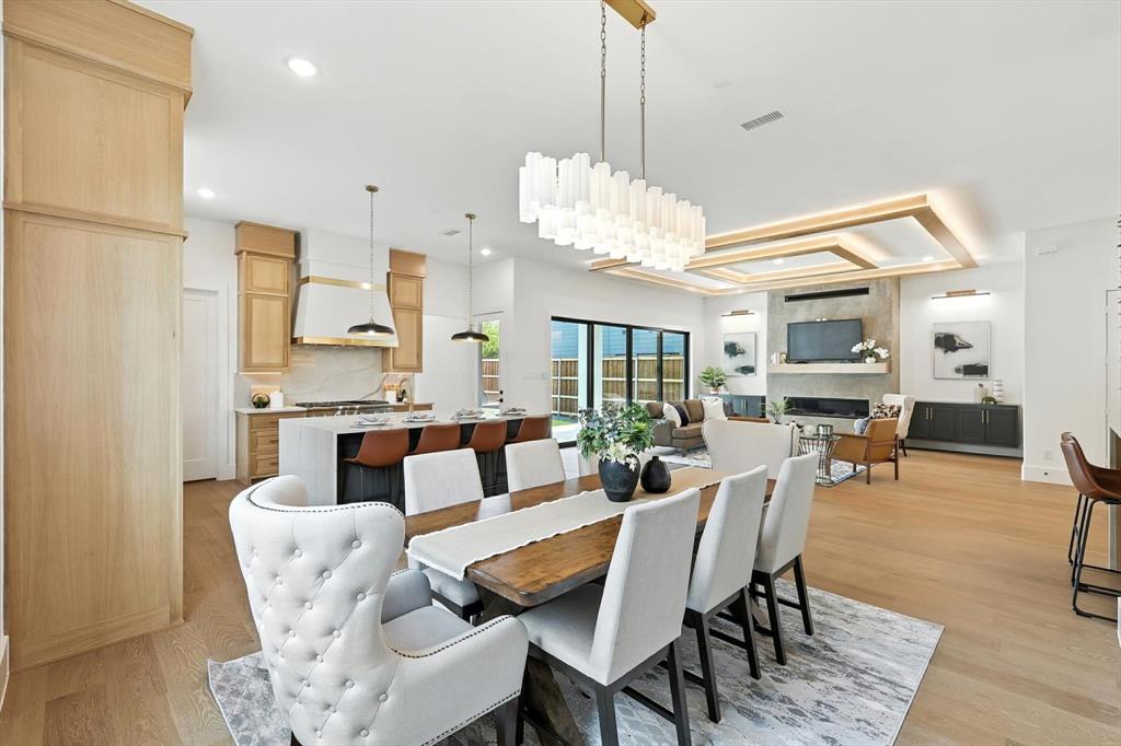 7618 Roper Street Dallas, TX 75209 - Photo 11 of 35 a dining room with furniture a chandelier and wooden floor