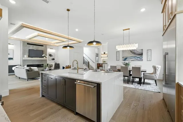 a kitchen with kitchen island a sink and a stove top oven with wooden floor
