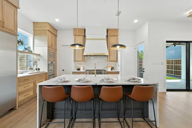 a kitchen with stainless steel appliances granite countertop a sink and chairs