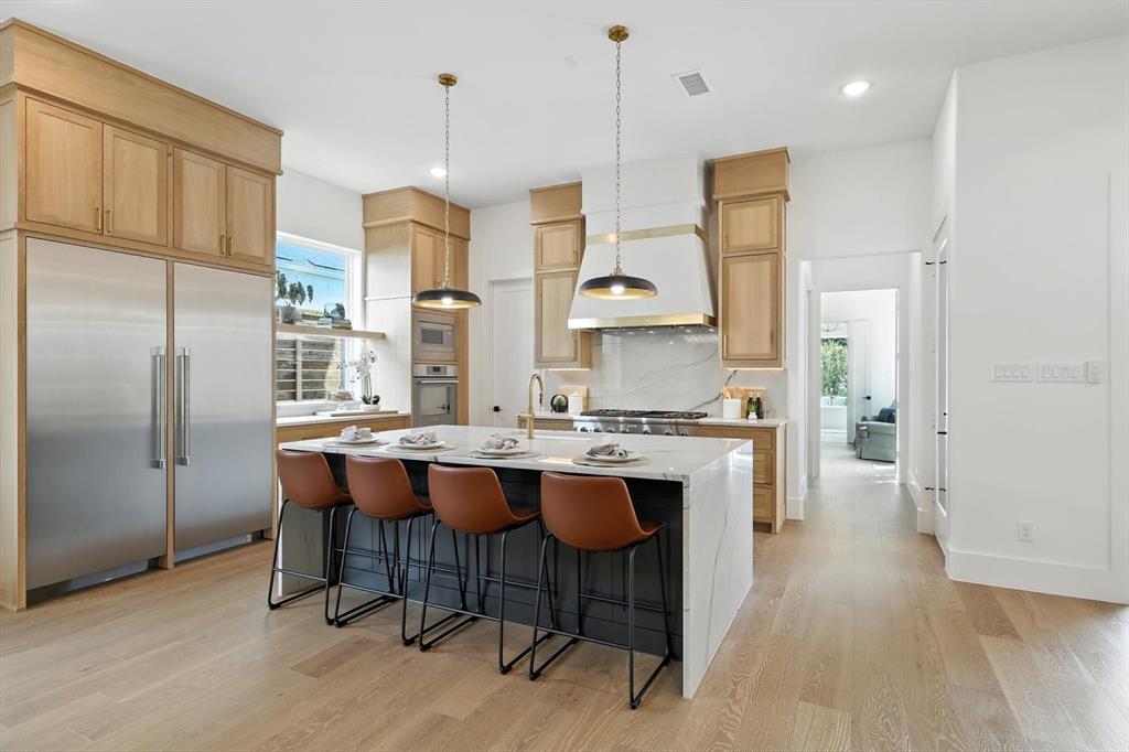 7618 Roper Street Dallas, TX 75209 - Photo 14 of 35 a kitchen with stainless steel appliances granite countertop a sink a stove a refrigerator and island with wooden floor