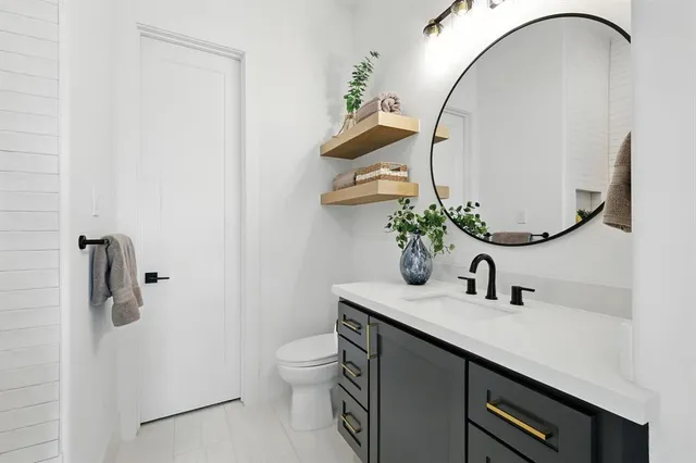 a bathroom with a sink a toilet and a mirror