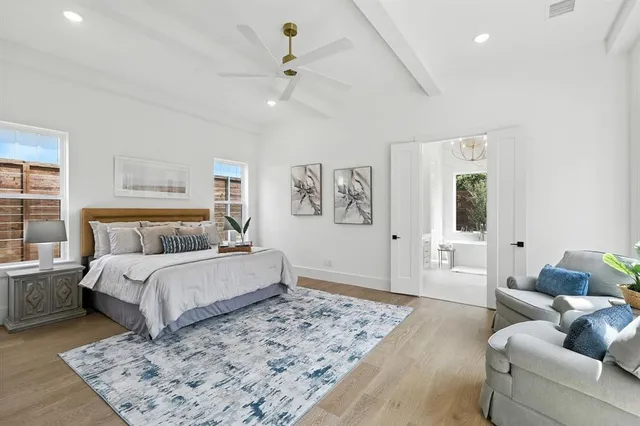 a spacious bedroom with a bed a couch and potted plant