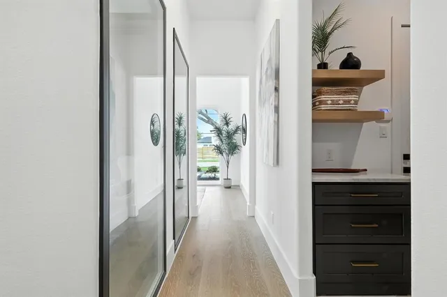 a view of a hallway with closet and wooden floor