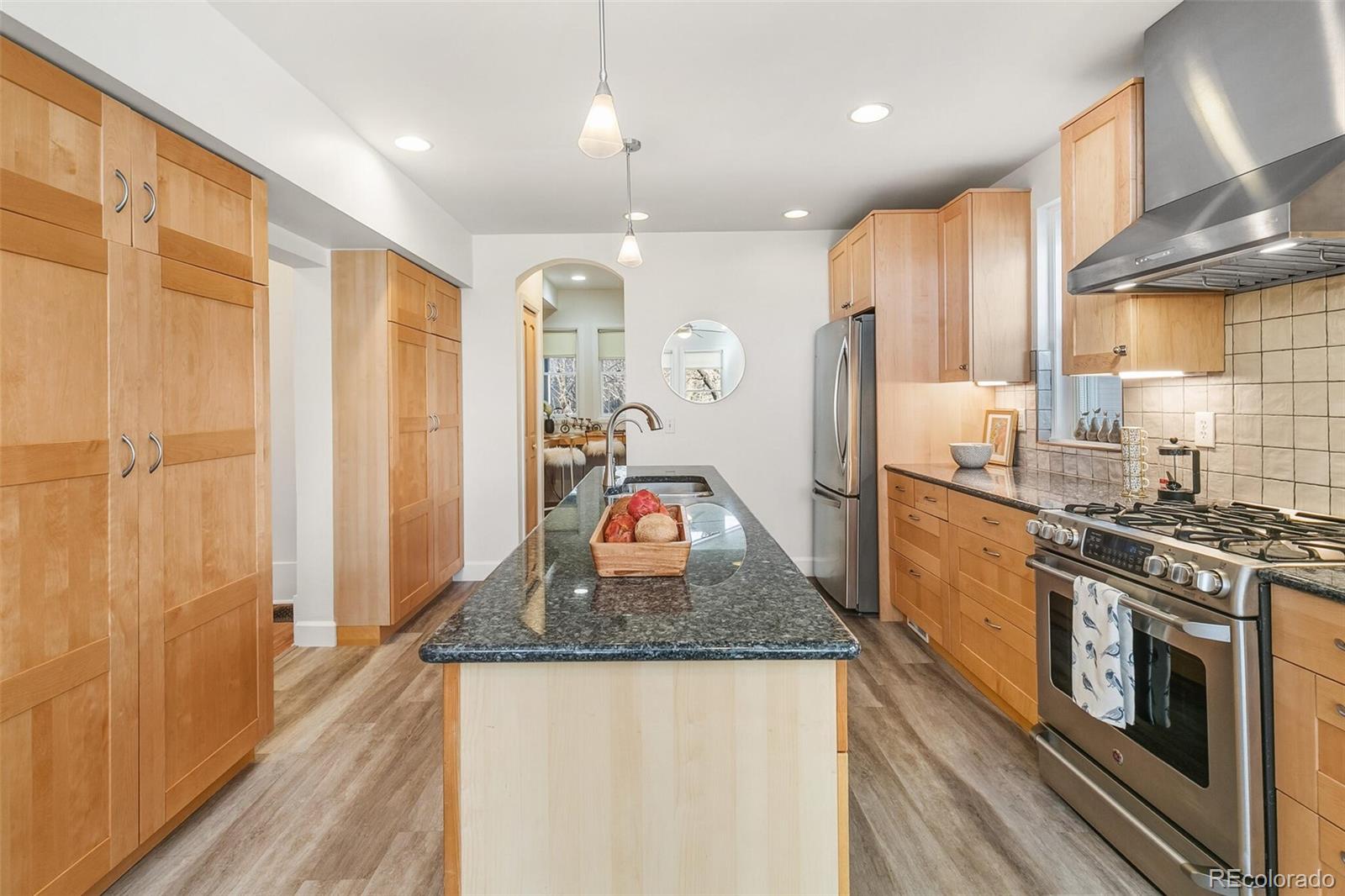 3885 Wolff Street Denver, CO 80212 - Photo 10 of 50 a kitchen with stainless steel appliances granite countertop a refrigerator a stove and a sink with wooden floor