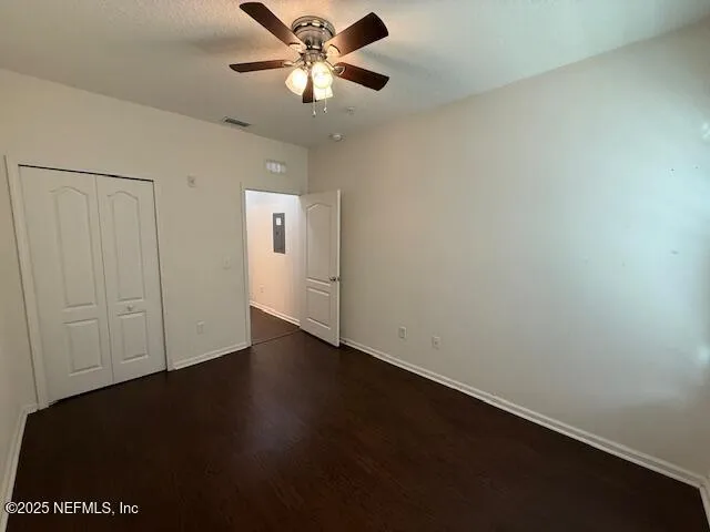 an empty room with a ceiling fan and wooden floor