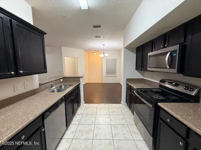 a kitchen with stainless steel appliances granite countertop a stove a sink and a microwave