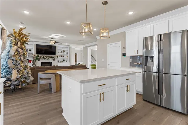 a kitchen with kitchen island white cabinets and stainless steel appliances