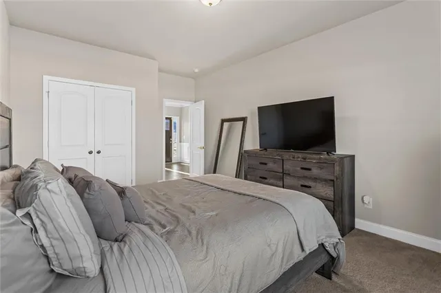 a bedroom with a bed and a flat tv screen on wall