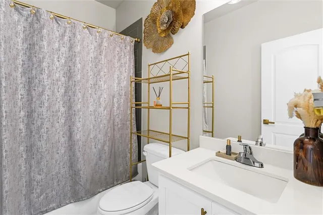 a bathroom with a sink a toilet and shower curtain
