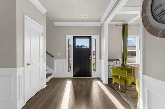 a view of a hallway with wooden floor and furniture