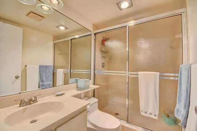 a bathroom with a sink vanity mirror and toilet