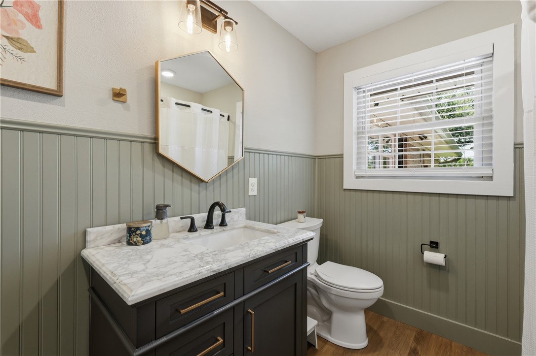 515 Crescent Drive Bryan, TX 77801 - Photo 26 of 43 Bathroom featuring wood-look LVP flooring, beadboard wall paneling, and a white window with blinds
