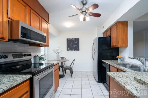 a kitchen with stainless steel appliances granite countertop a stove microwave and sink