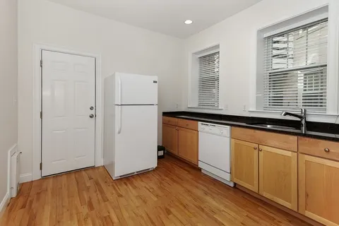 a kitchen with granite countertop white cabinets and white appliances