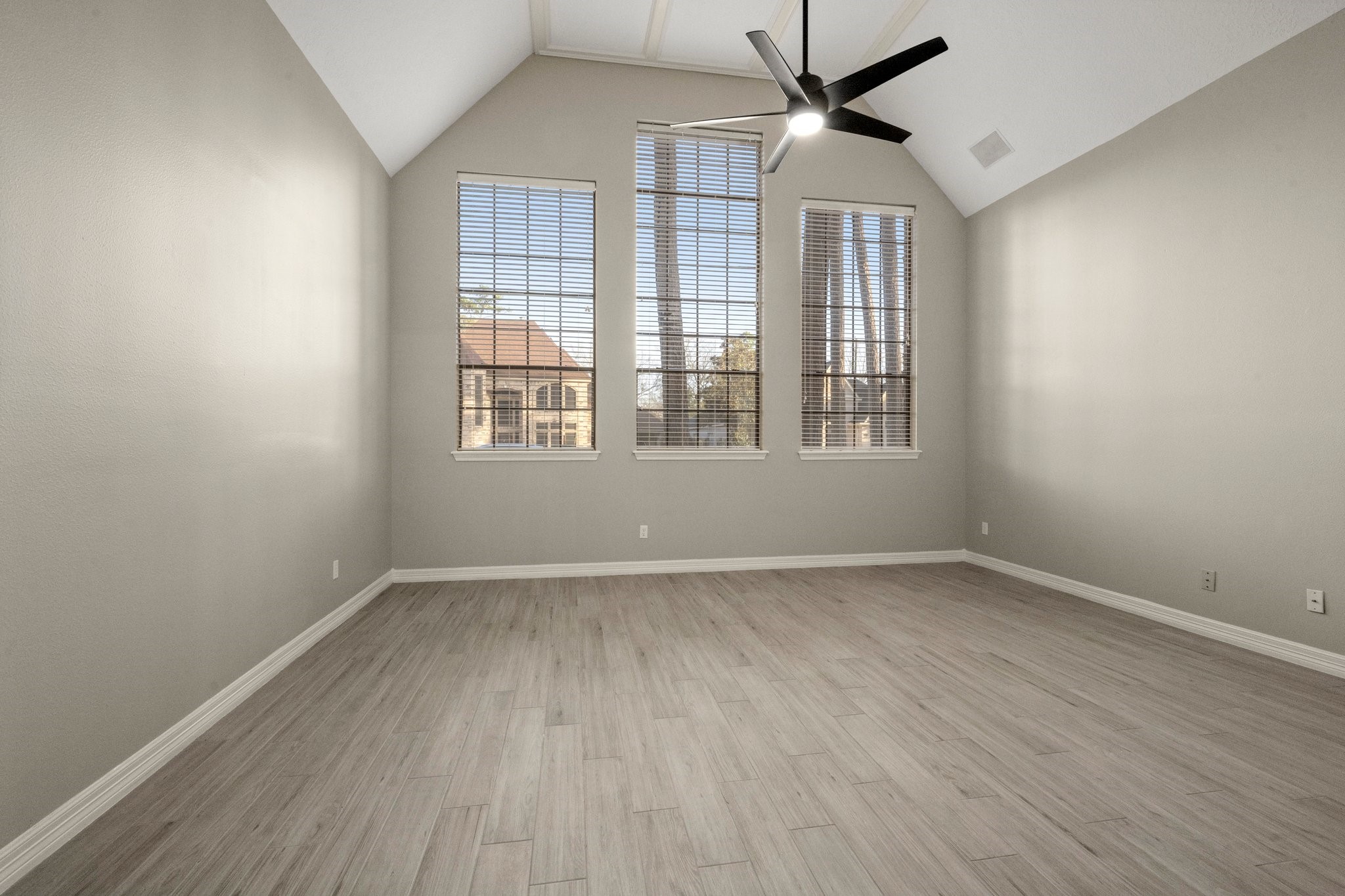 8222 Redchurch Drive Spring, TX 77379 - Photo 11 of 36 an empty room with wooden floor ceiling fan and windows