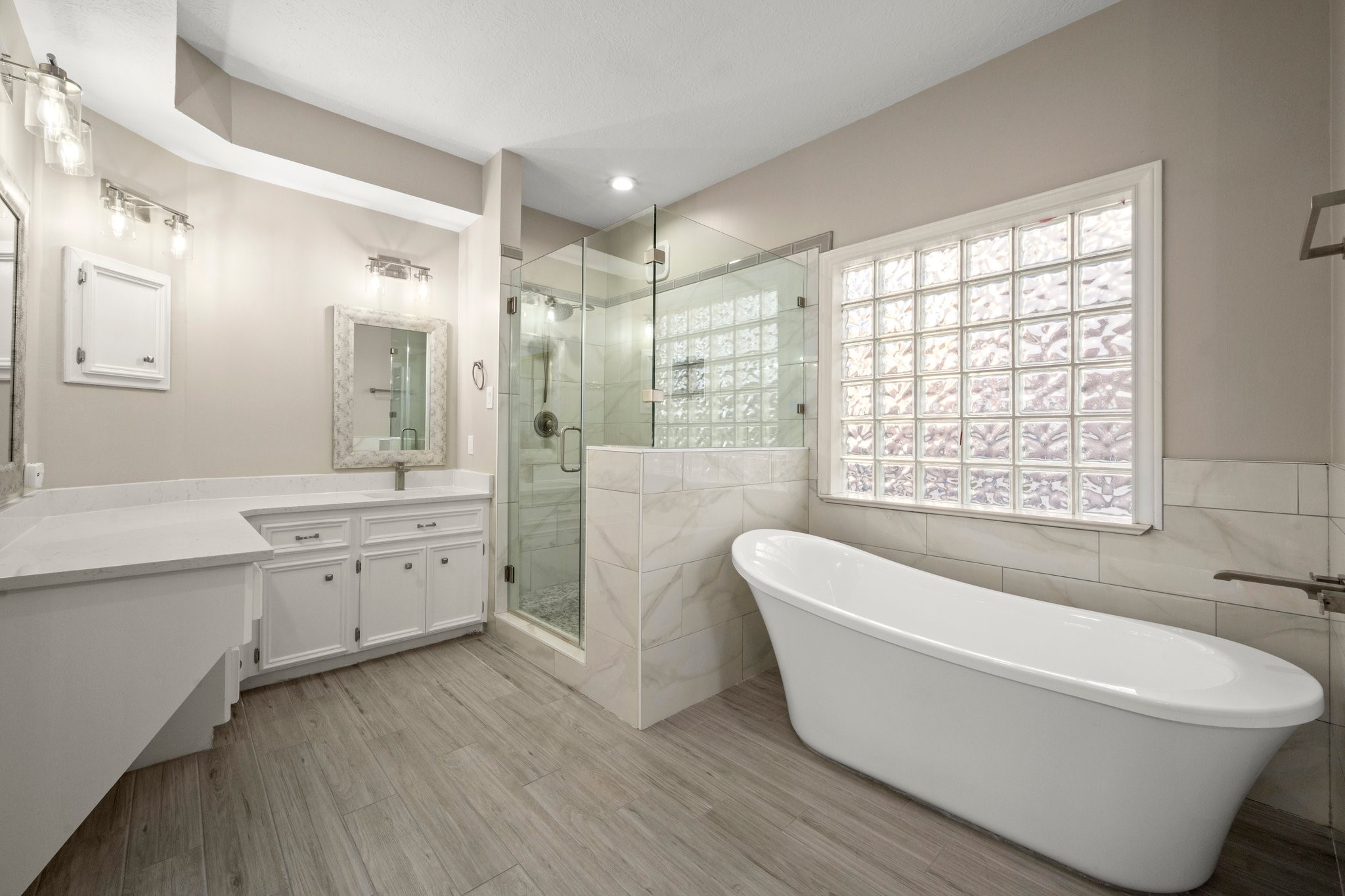 8222 Redchurch Drive Spring, TX 77379 - Photo 12 of 36 a bathroom with a bathtub a double vanity sink a window and a shower