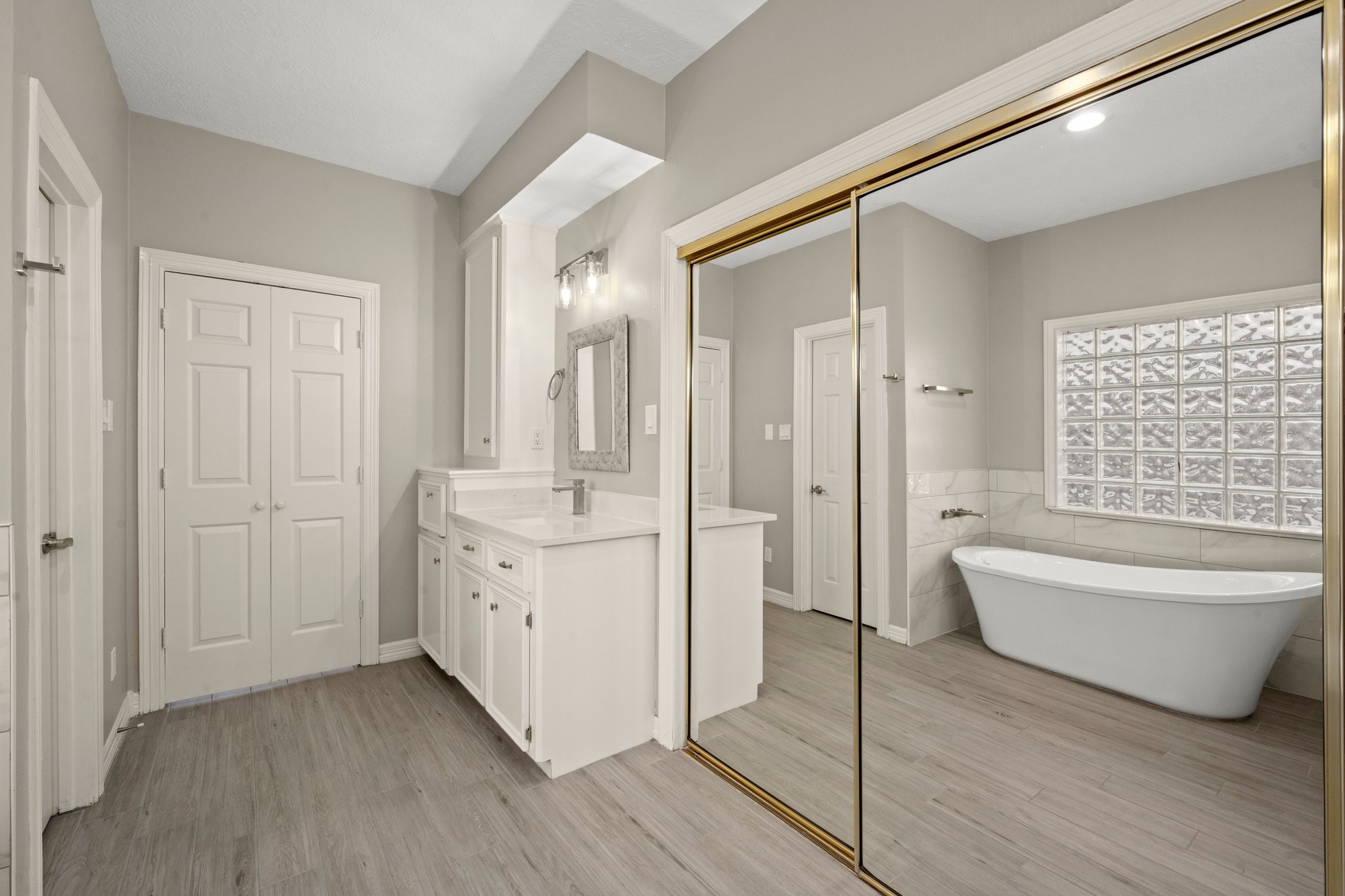 8222 Redchurch Drive Spring, TX 77379 - Photo 13 of 36 a bathroom with a double vanity sink a mirror and a bathtub