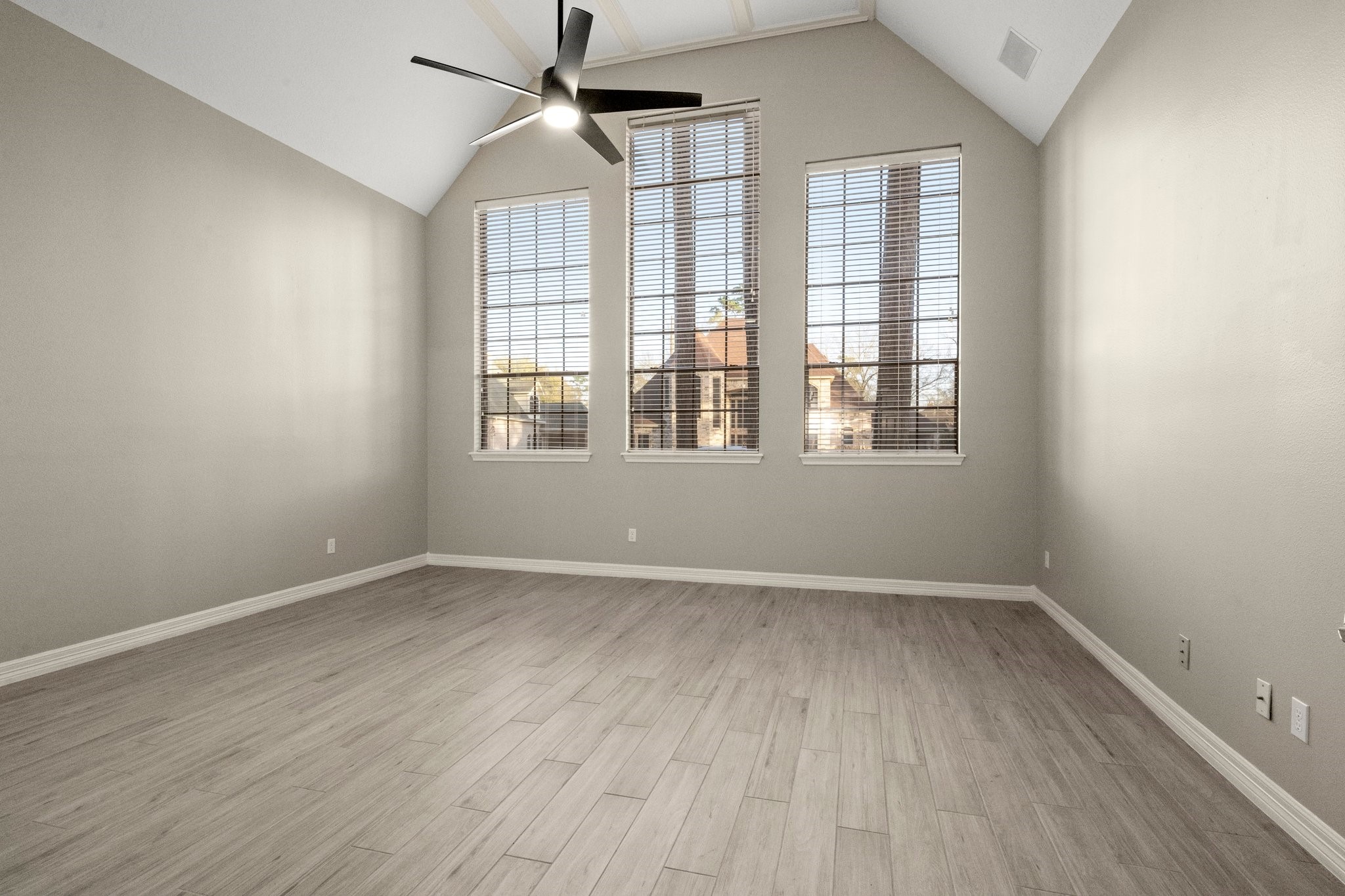 8222 Redchurch Drive Spring, TX 77379 - Photo 10 of 36 an empty room with wooden floor ceiling fan and windows