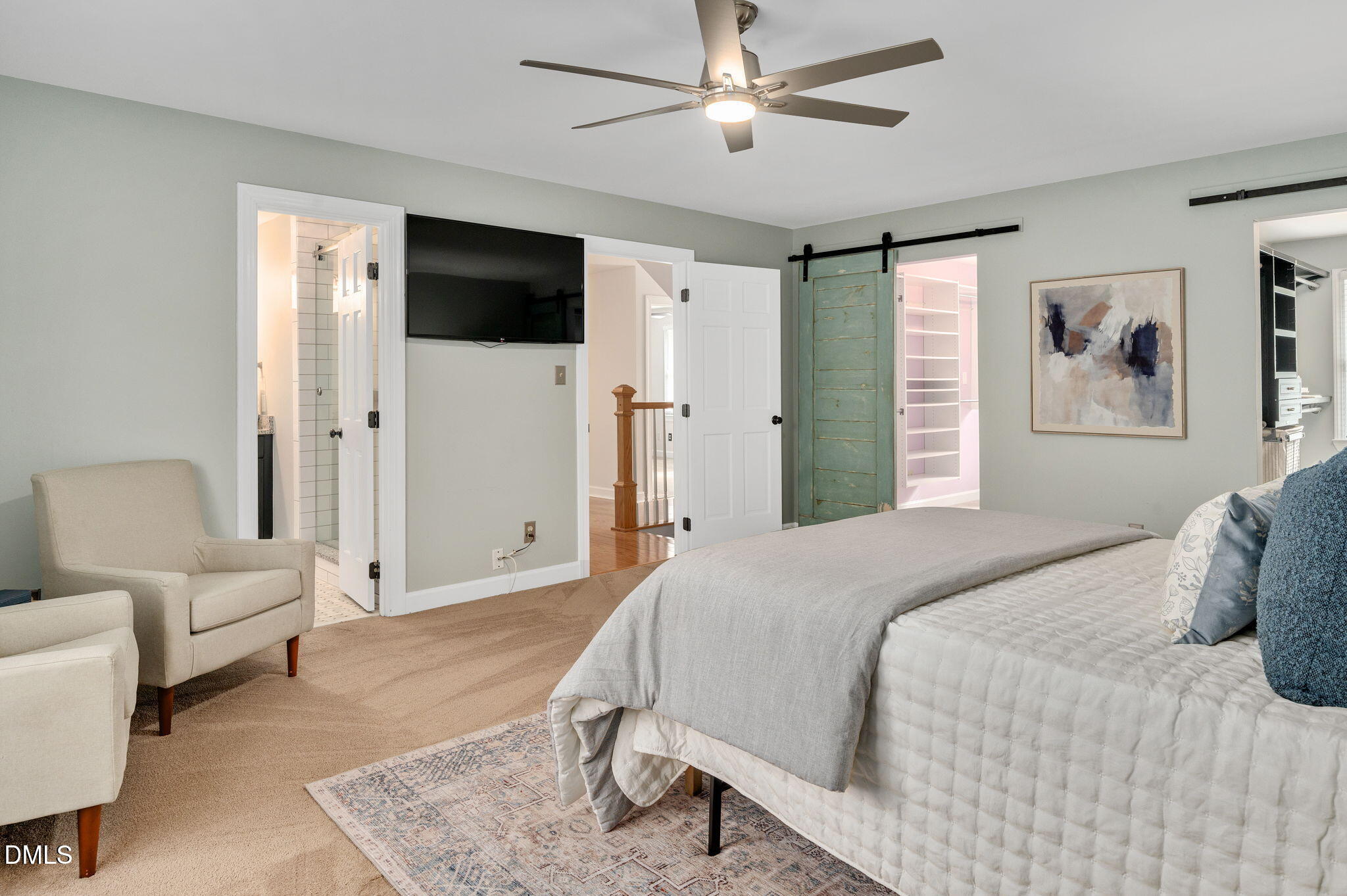 8325 Stryker Court Raleigh, NC 27615 - Photo 23 of 53 a bedroom with a large bed a chandelier and a flat screen tv