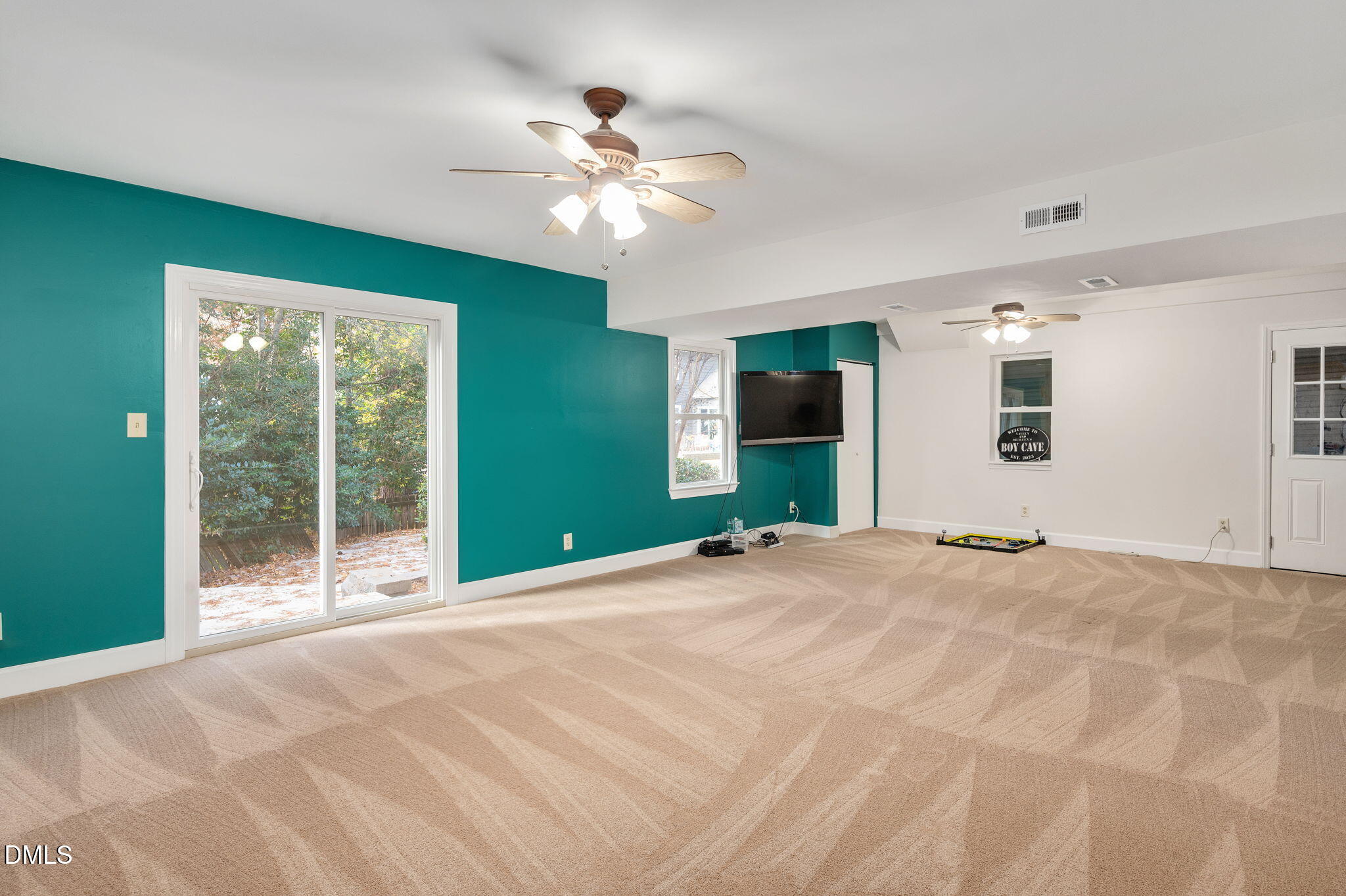 8325 Stryker Court Raleigh, NC 27615 - Photo 41 of 53 a view of an empty room with a chandelier fan and a large window