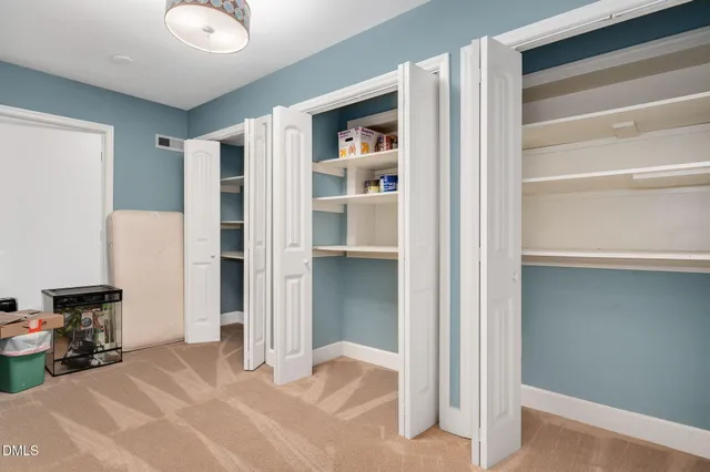 a view of a room with gym equipment and a chandelier fan