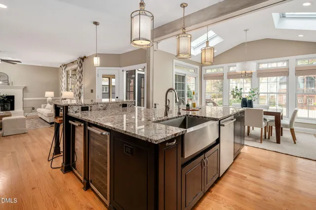 a kitchen with stainless steel appliances granite countertop a refrigerator a stove and a wooden floors