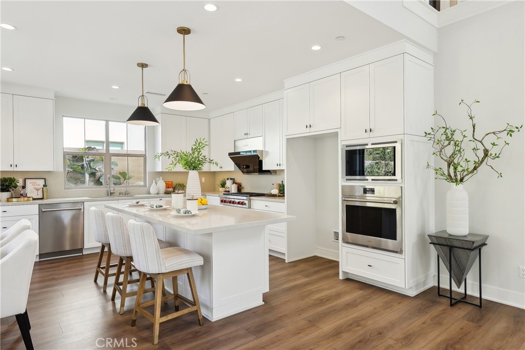 161 Sabbia Irvine, CA 92602 - Photo 5 of 11 a kitchen with white cabinets and stainless steel appliances